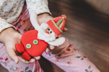 niña feliz y sonriente sosteniendo en sus manos objetos decorativos navideños, bolas o esferas...