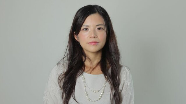 Beautiful asian woman opens her eyes and stares the camera. Emotionless, Still, Protest. 25P