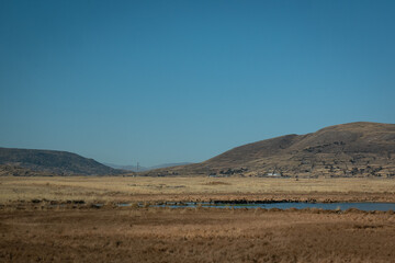 Mountains in the Midst of Dry and Yellow Soil in Contrast to a Beautiful Clear Blue Sky