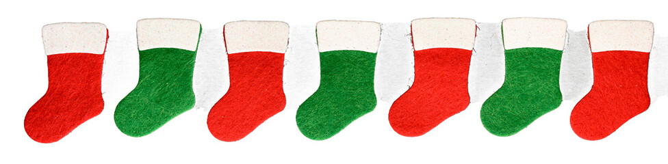 Row of small traditional red and white, and green and white, felt Christmas stockings, celebrating winter holidays
