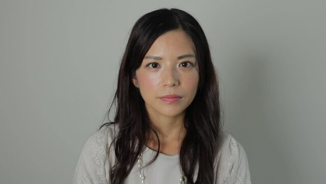 Beautiful Japanese woman opens her eyes and stares the camera. Emotionless, Still, Protest. Dolly in. 25P