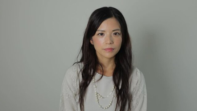 Beautiful Japanese woman opens her eyes and stares the camera. Emotionless, Still, Protest. Dolly out. 25P