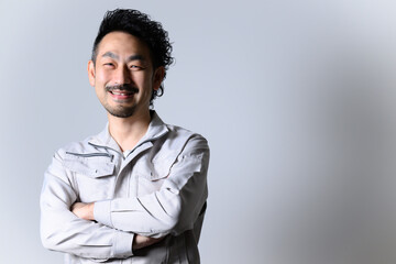 Obraz premium 目標に向けてニコニコする作業着姿の経営者
