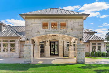 A luxury white home with a green lawn 