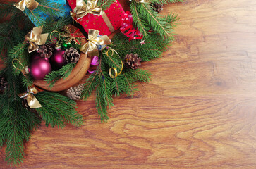 Christmas decorations from fir branches, cones and balls on a wooden texture background. Copy space.
