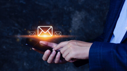 Businessman holding touching mobile phone and checking email online with virtual interface technology.Direct marketing, online message, E-mail, electronic mail,communication concept.