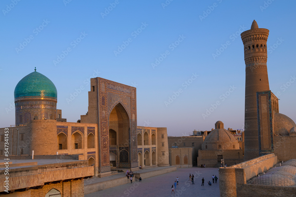 Wall mural Mir-i-Arab madrasah and Poi-Kalon minaret on a evening twilight. Historical,  center of Bukhara, Uzbekistan