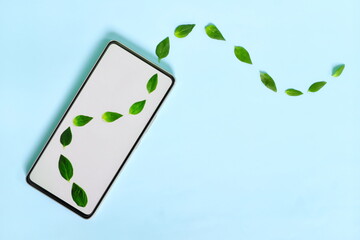 Mobile phone smartphone with fresh green leaves coming out. Environment friendly and green...