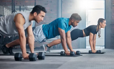 Foto auf Acrylglas Fitness Group, workout and dumbbell push up at gym for muscle, power or strength. Teamwork, sports or energy of people, athletes or bodybuilder friends exercise or training at fitness center for healthcare.