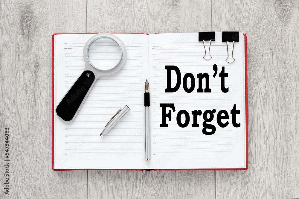Poster open notepad and sticky notes with word don't forget on top of wooden table
