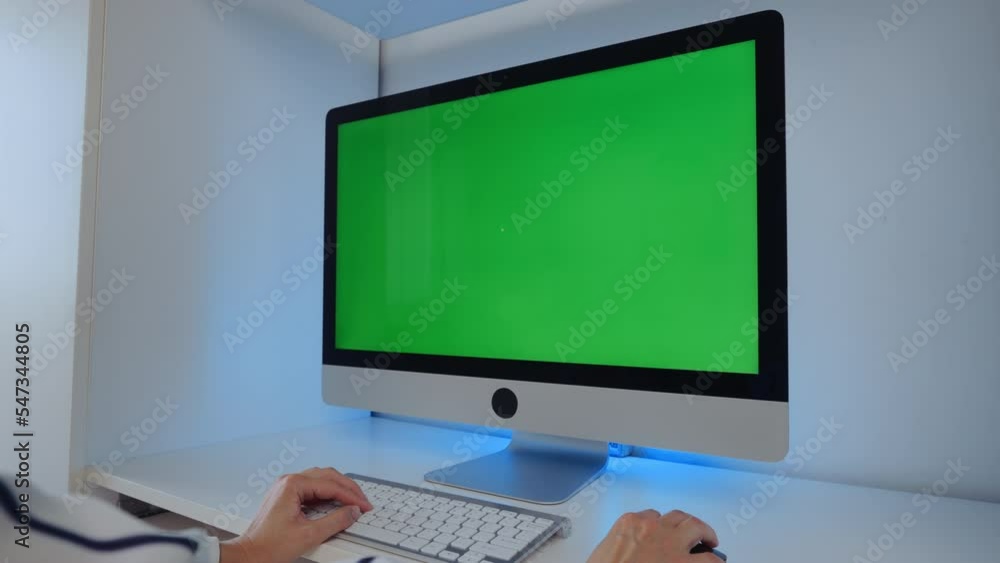 Poster employee sitting at workplace display computer with green screen typing on keyboard in office