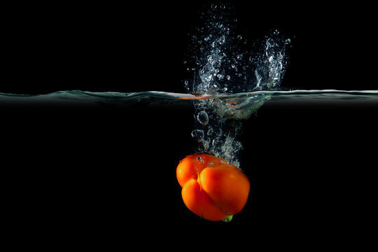Red pepper in water with splashes