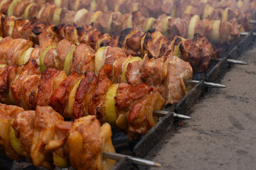 A grilled dish prepared on metal skewers. Shish kebab. Shashliks ina a row