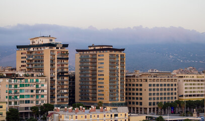 Fototapeta premium Residential Homes in city with mountains in background in Palermo, Sicily, Italy. Sunrise Sky.