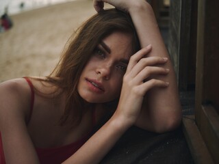 Obraz premium Young woman with a sad look looks into the camera portrait on the beach on a summer vacation trip to the sea