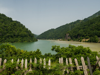 View of the mountain valley. The confluence of two different rivers into one. Beautiful landscape. Mountains of Georgia. Old fallen fence in the foreground. No people. copy space