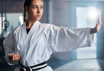 Karate, fitness and sport with woman, workout and training for fight, fitness and exercise in gym. Female athlete and champion attitude for self defense, training and power exercise with motivation