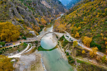 Aerial view of the stone bridge of Konitsa over Aoos river with automn colors , in Zagori, Epirus,...