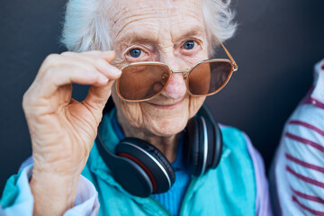 Glasses, cool and fashion portrait of old woman with music headphones, luxury senior style or...