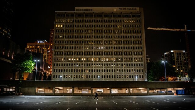 View of a man walking along the parking lot before the Paccar building at night