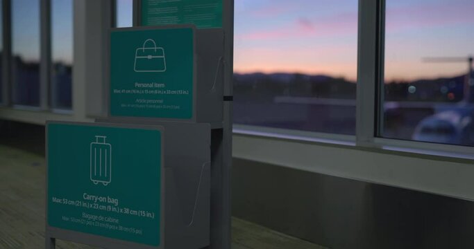 Carry on baggage size guide at aiport gate terminal - wide shot