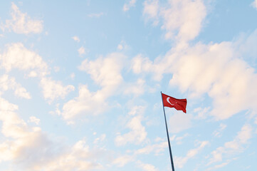 National Turkish flag waving against blue sky.