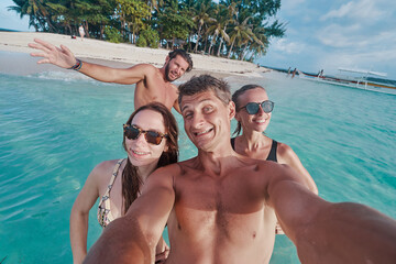 Having fun on the beach together. Vacation with friends. Group of young people taking selfie on the...