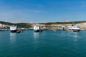 ferries lined up in the ferry terminal of Dover on the English Channel with the White Cliffs of Dover in the background