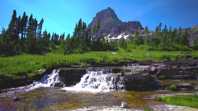 Mountain Peak With Waterfall And Forest In Glacier National Park Montana