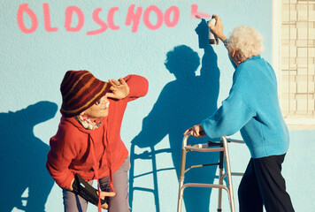 Senior women, friends and spray paint for vandalism, graffiti and street art to spray old school on...