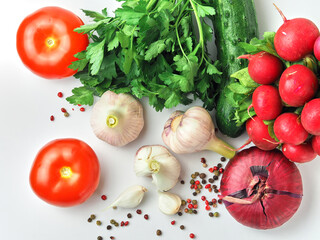 Young garlic, tomato, parsley, cucumber, radish and pepper on a clean white surface