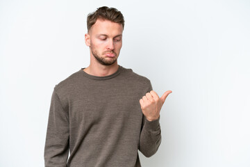 Young blonde caucasian man isolated on white background unhappy and pointing to the side