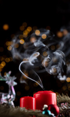 Two freshly dried red candles on the New Year's table. white smoke comes from the wicks