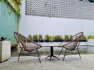 Set of furniture for the garden or terrace. comfortable chairs and tables in a vintage setting. rattan furniture and marble tables beside the pool