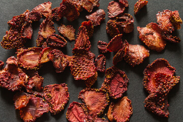 dried strawberries on a dark background scattered dried fruits