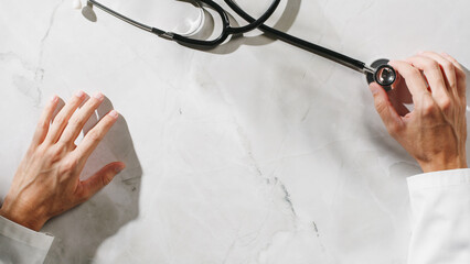 Hand of a doctor with stethoscope on the table