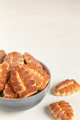 Grey bowl with Christmas tree shaped biscuits on a white background. Copy space.