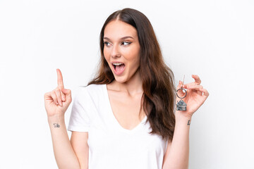 Young caucasian woman holding home keys isolated on white background intending to realizes the solution while lifting a finger up