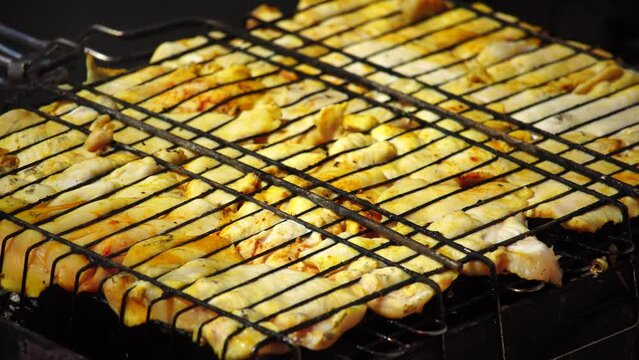 close-up of flattened out barbecued golden crispy skin chicken tabaka on grid, side view from above