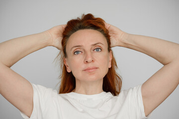 Portrait of a beautiful adult woman on a gray background. Happy and calm people.