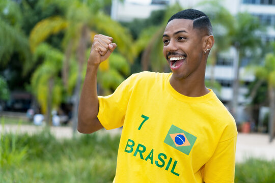 Excited young man from Brazil with yellow football jersey