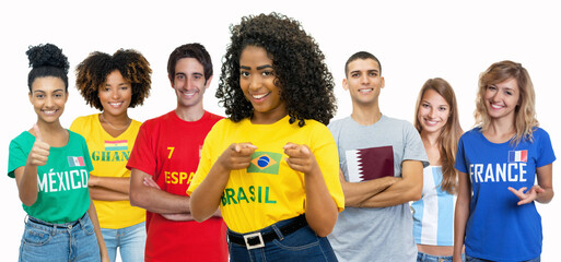 Laughing soccer fan from Brazil with supporters from Spain Ghana Mexico Qatar Argentina and France