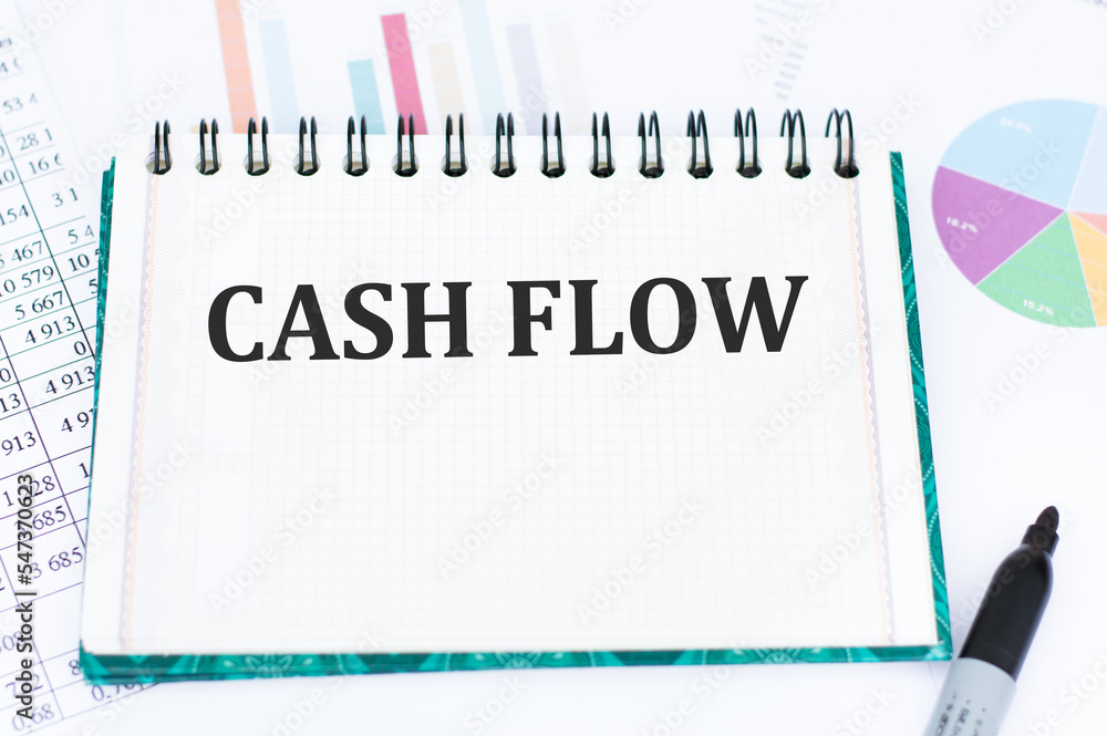 Poster text cash flow on a notebook with charts and reports on the table, business concept