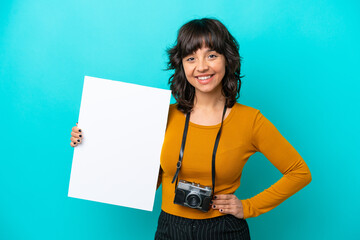 Young photographer latin woman isolated on blue background holding an empty placard with happy...