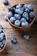 Freshly picked blueberries in  bowl. Bilberry on wooden Background. Blueberry antioxidant. Concept for healthy eating and nutrition