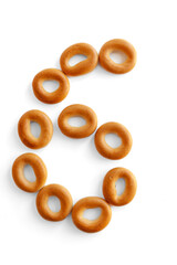 Bagels font. Alphabet from set of small dry bagels isolated on white background. ABC symbols.  Number 6.