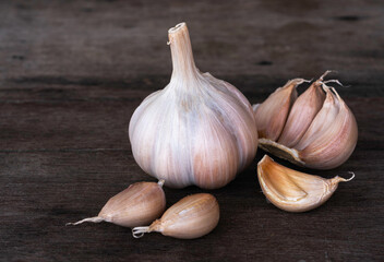 Garlic Bulb and cloves on vintage wooden background.
