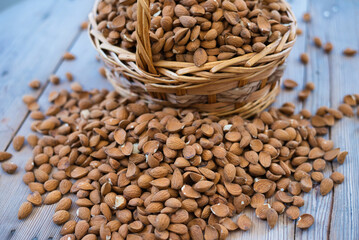 almonds in a basket on a wooden table. Delicious almonds, a variety of Greek origin and late flowering and harvesting retsιοu