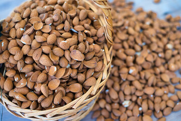 almonds in a basket on a wooden table. Delicious almonds, a variety of Greek origin and late flowering and harvesting retsιοu