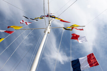 Flag signals on a mast with summer skies